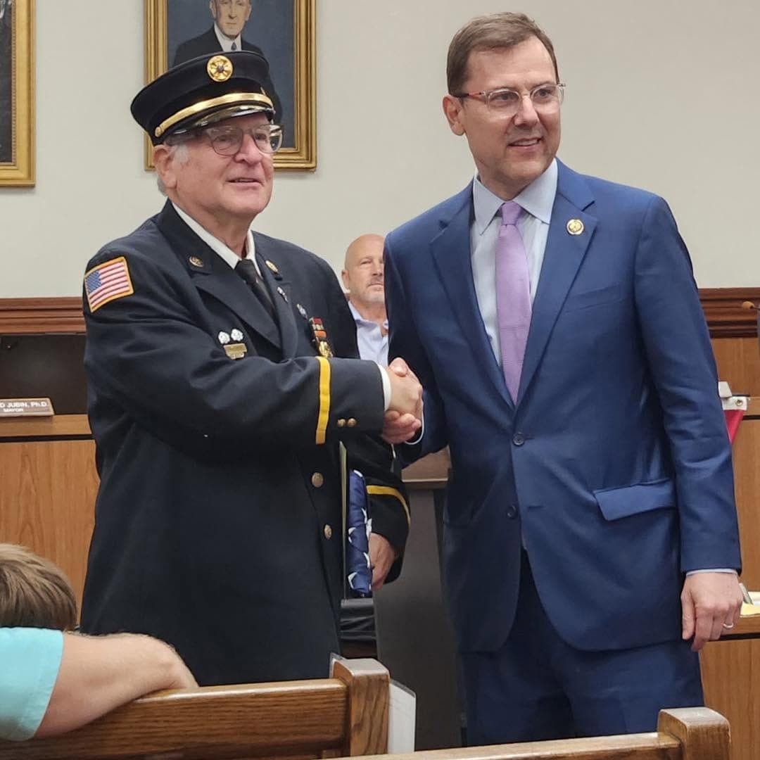 Former Watchung Fire Chief Gary Greves is congratulated by Congressman Tom Kean during a Borough Council meeting recognizing Greves' 55 years of service.